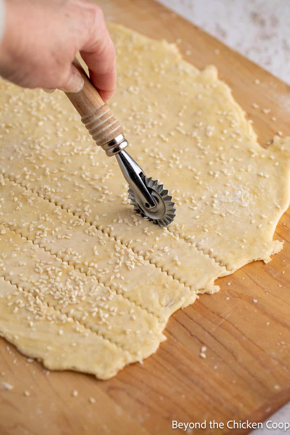 Cutting homemade crackers with a pastry wheel. 