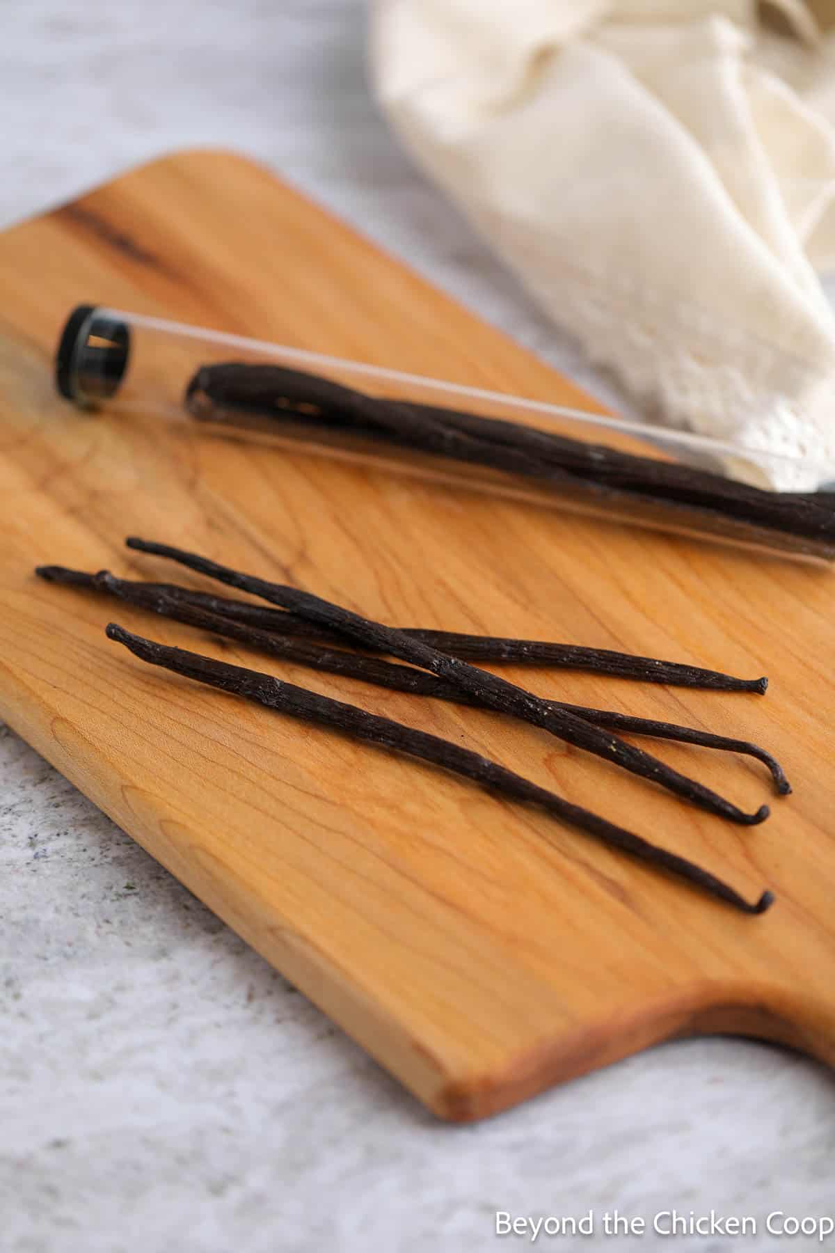 Vanilla beans on a wooden cutting board. 