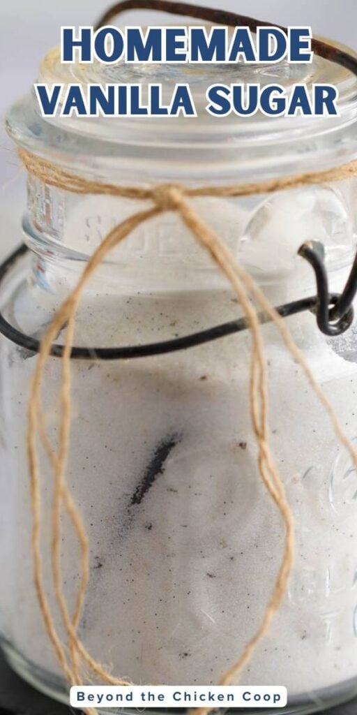 A glass jar filled with sugar infused with a vanilla bean.