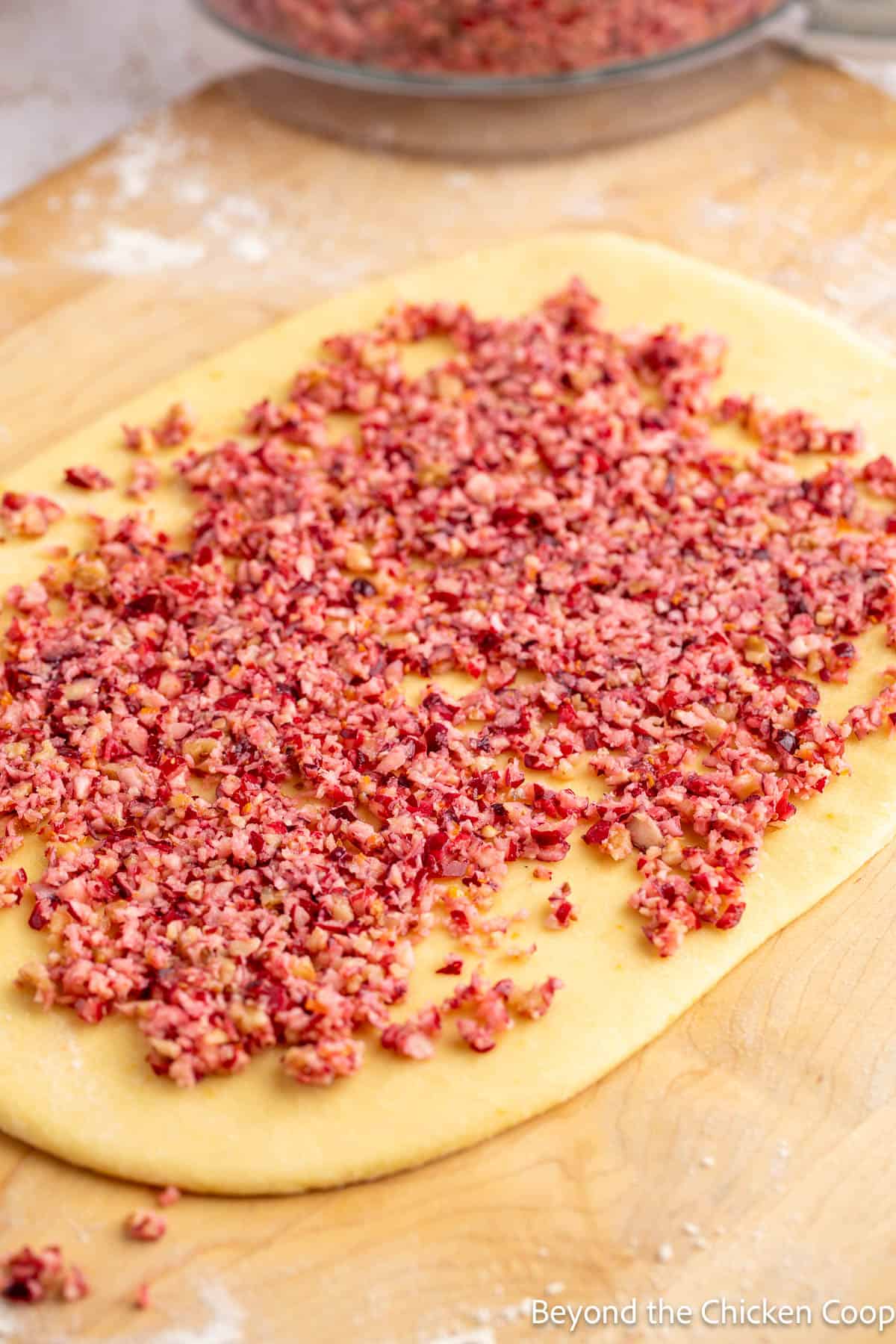 Chopped cranberries on rolled out dough. 