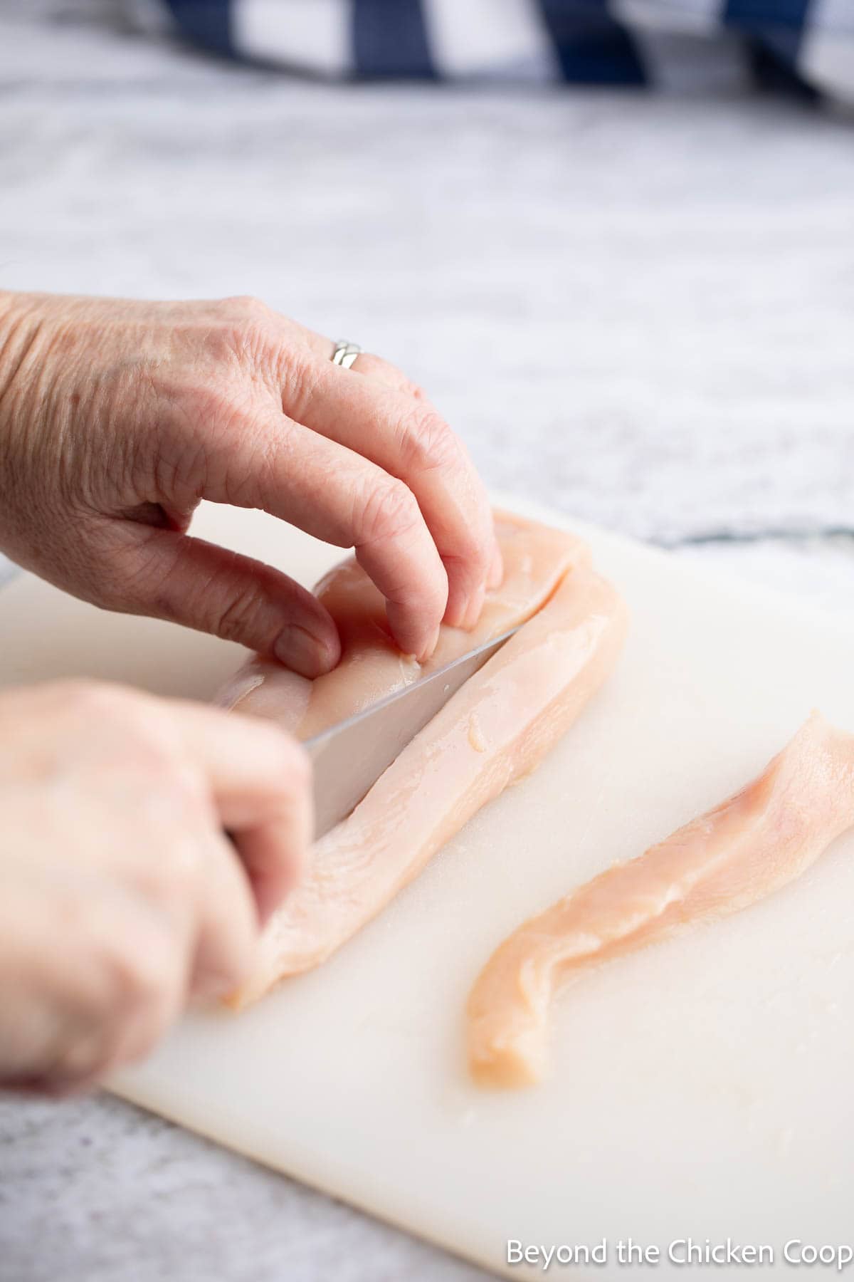 Cutting a chicken breast into strips. 