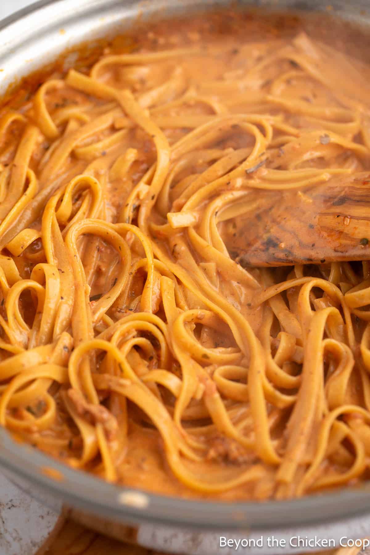 Creamy sauce with fettuccine in a pan. 