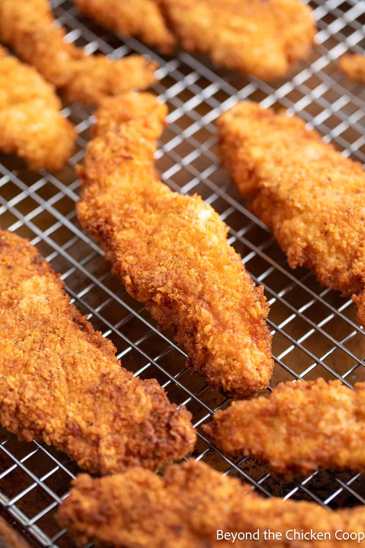 Fried chicken strips on a baking rack. 