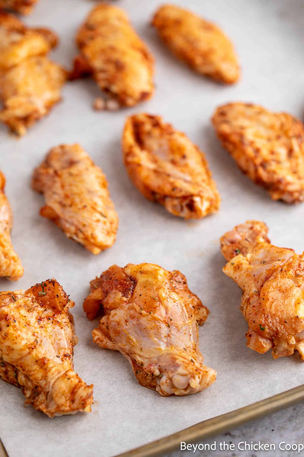 Uncooked chicken wings on a baking sheet. 