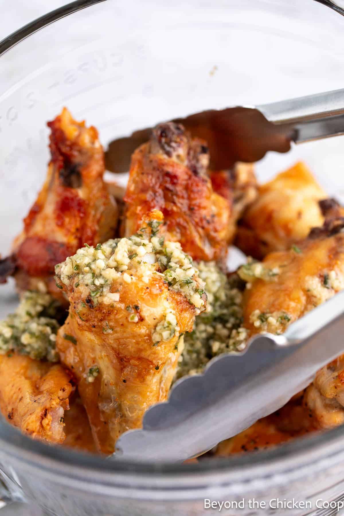 Adding garlic butter to baked wings. 