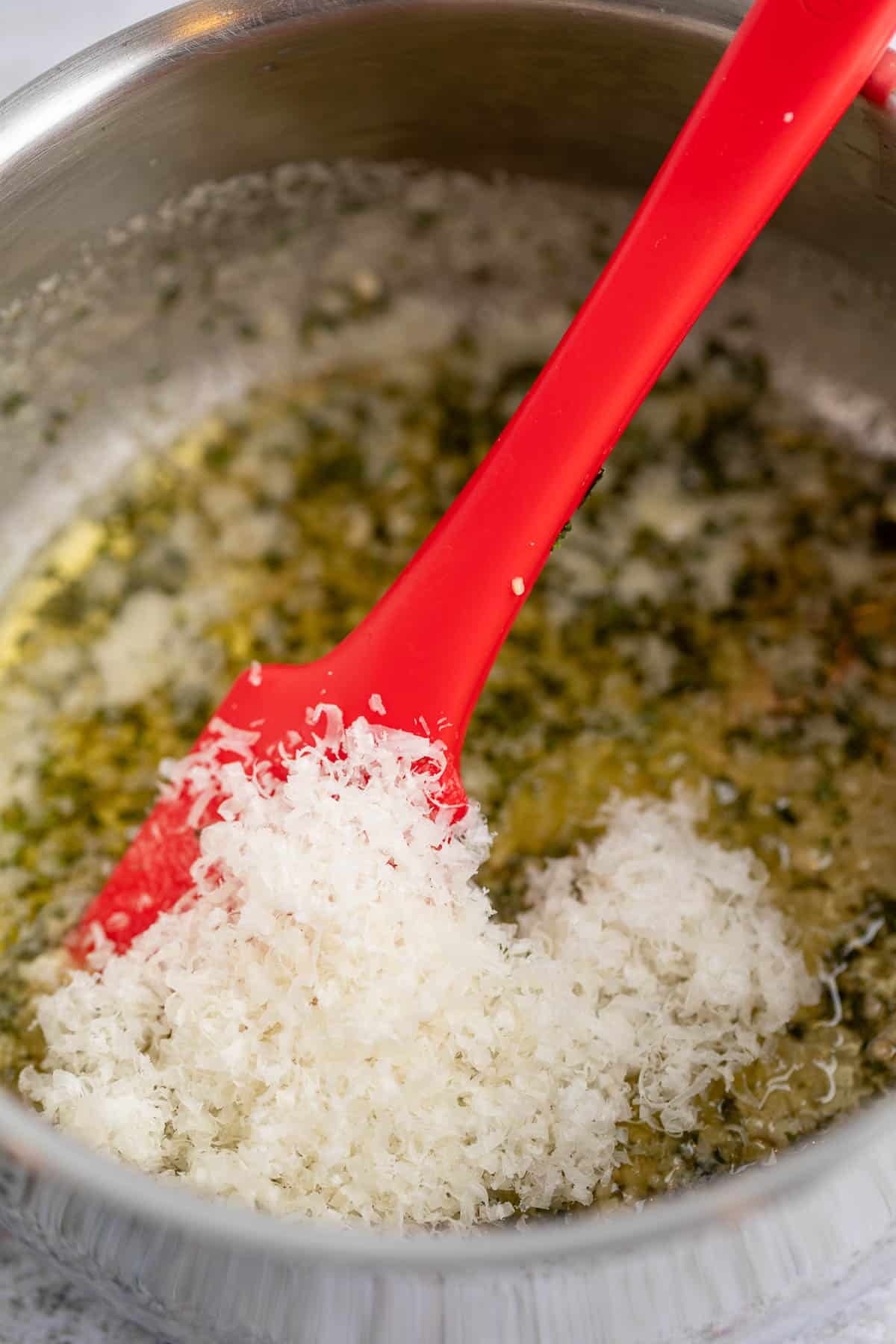 Stirring parmesan into melted butter.