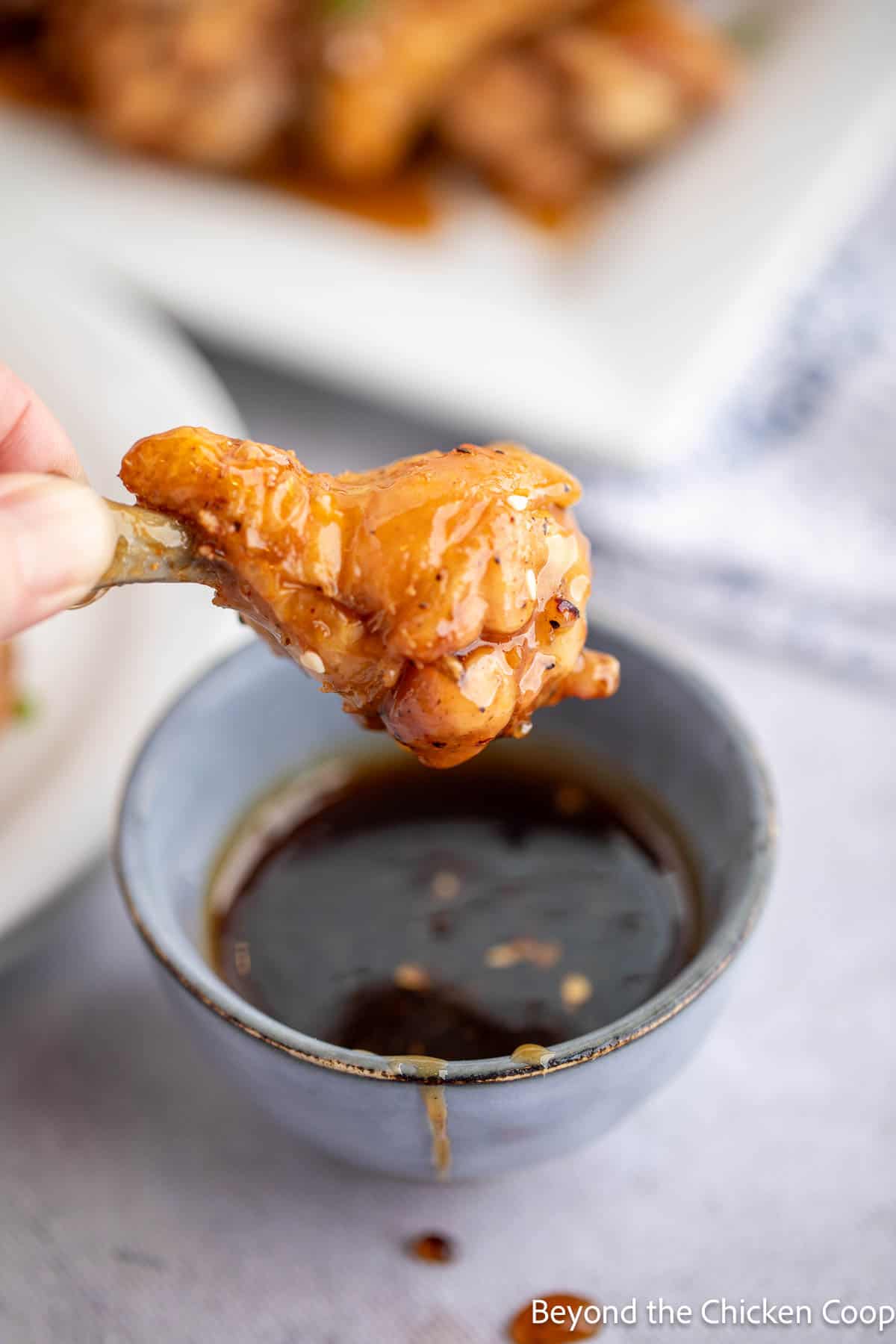 Baked chicken wing dipped into a sauce. 