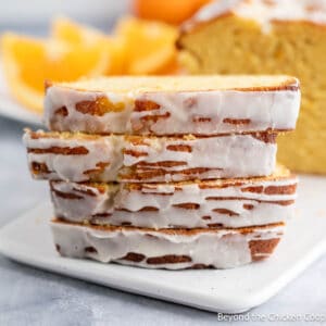 A stack of slices of orange pound cake topped with a glaze.