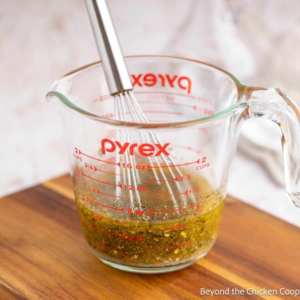 Homemade dressing in a glass measuring cup. 