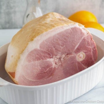 A large ham in a casserole dish.
