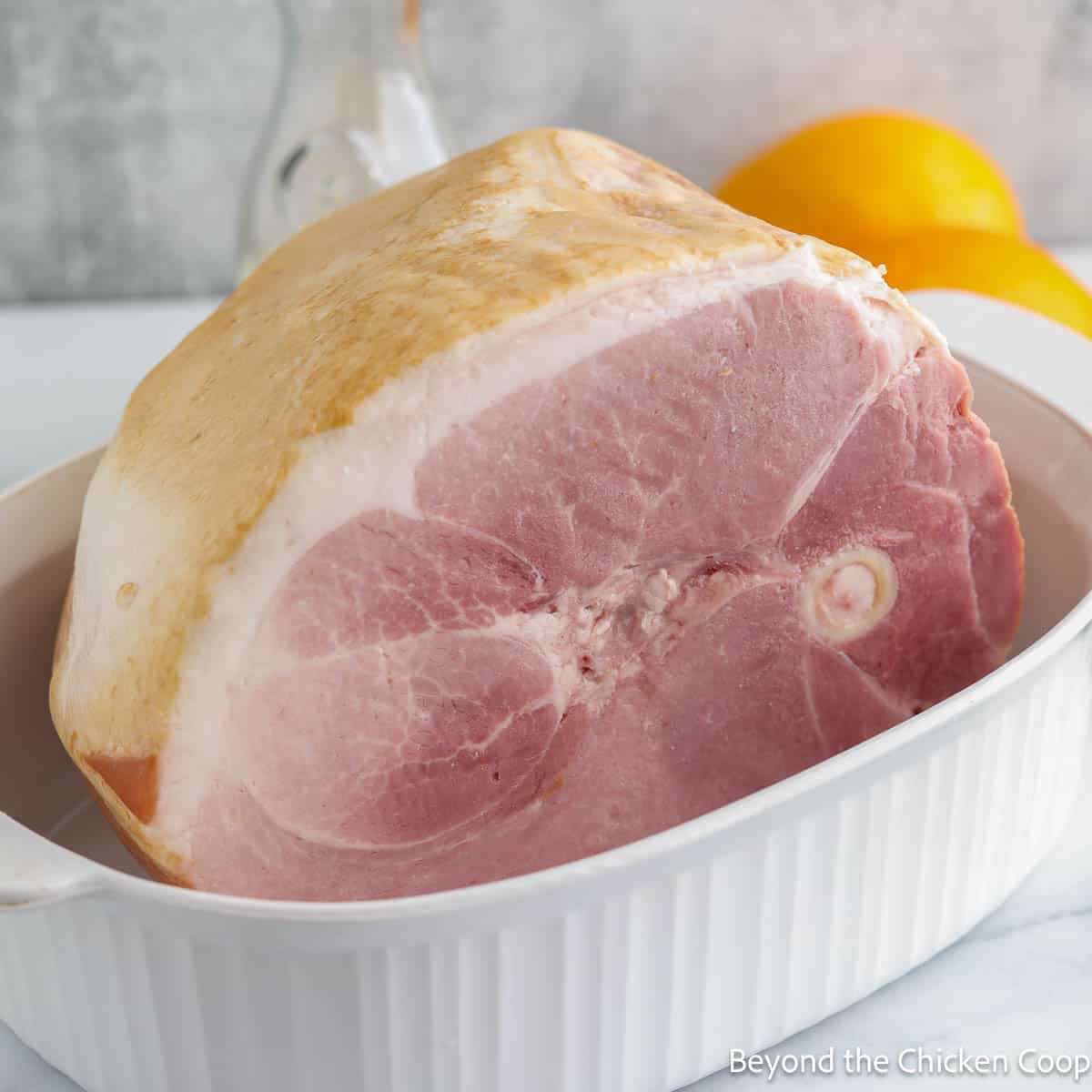 A large ham in a casserole dish.