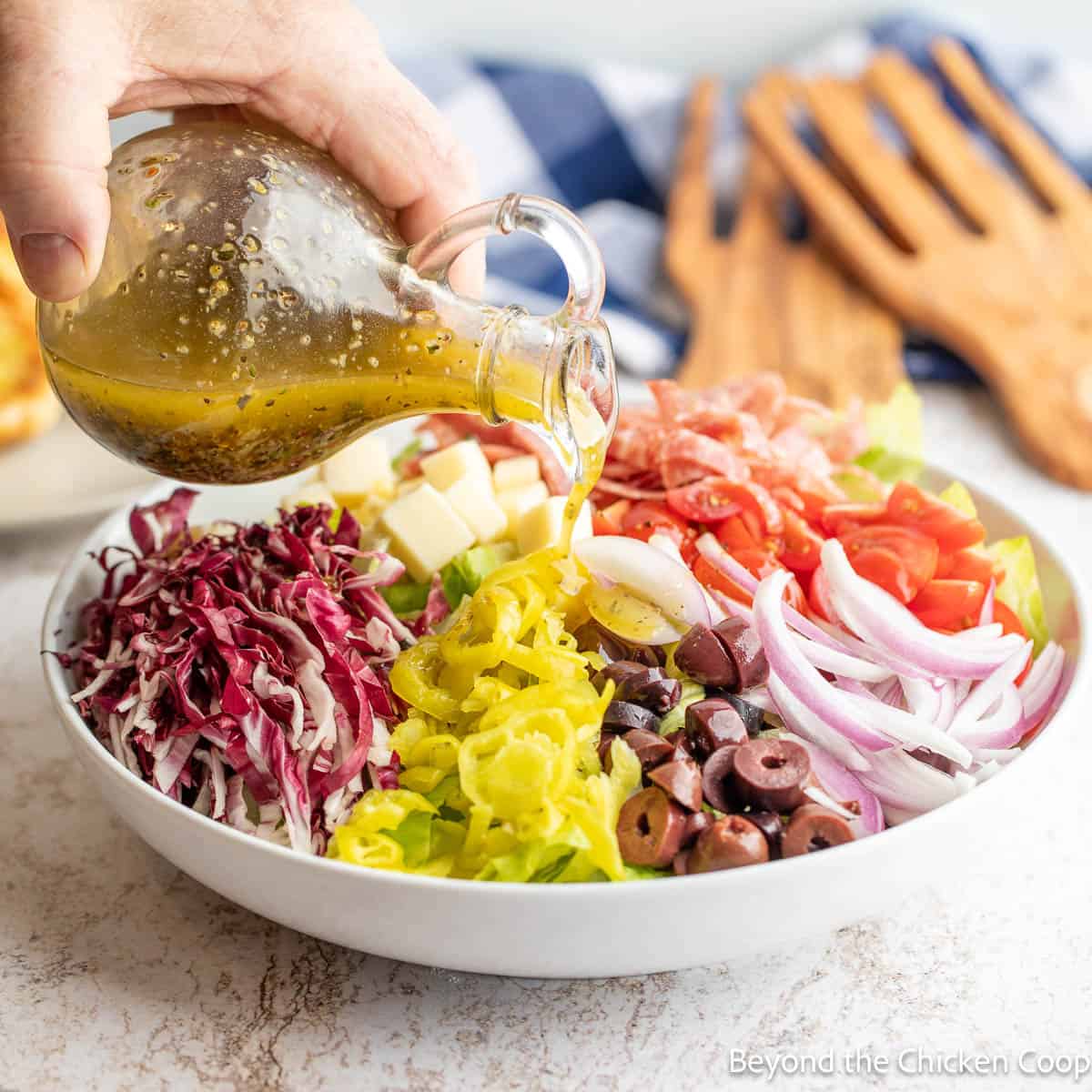 Pouring dressing over a chopped salad. 