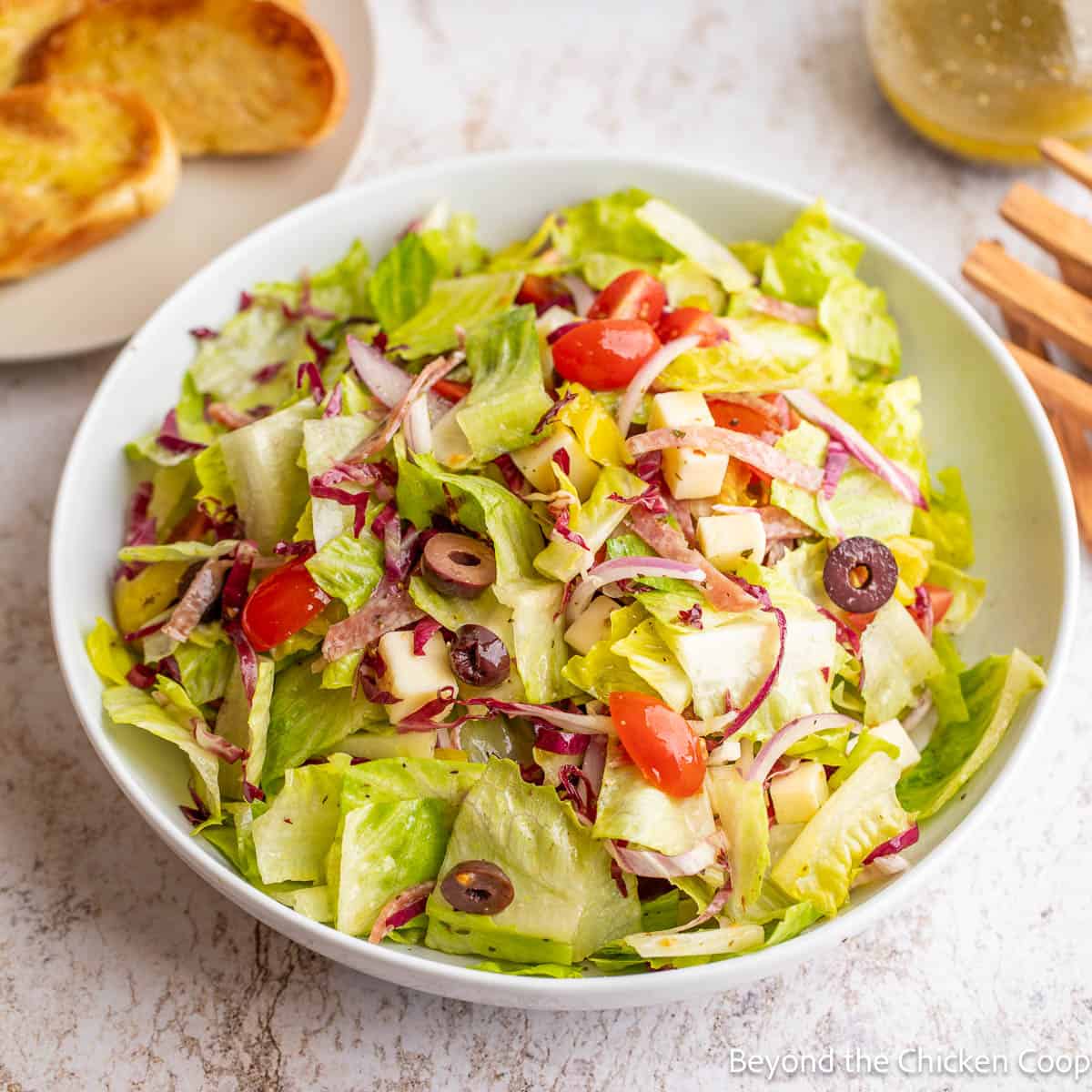 An Italian Chopped Salad in a white mixing bowl. 