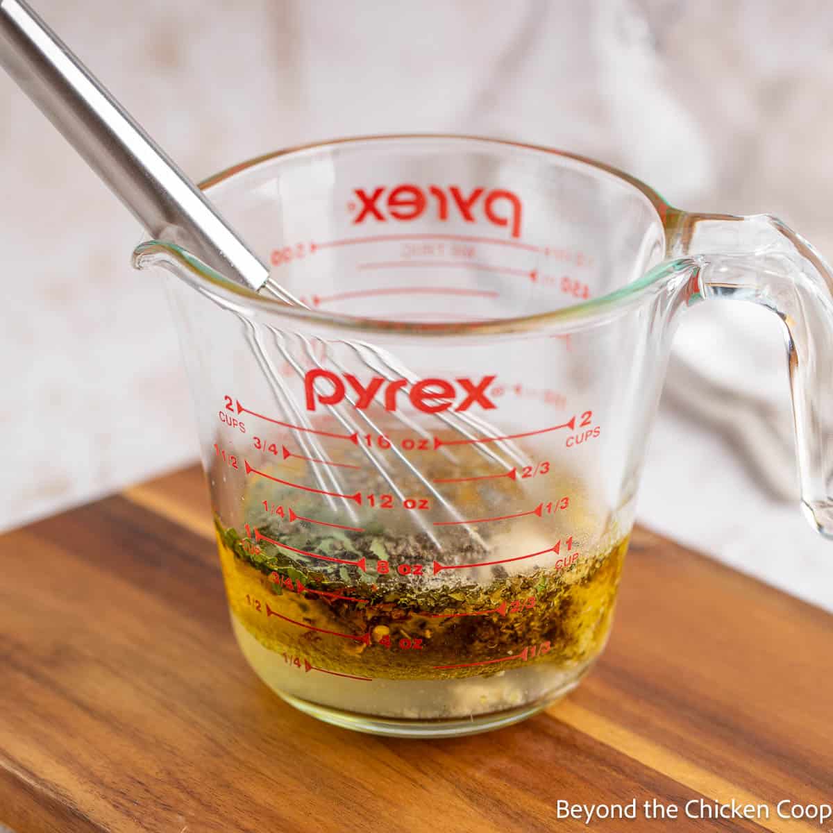 Making salad dressing in a glass measuring cup. 