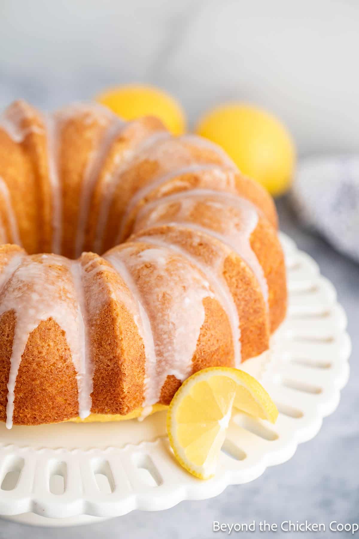 A lemon bundt cake on a cake stand. 