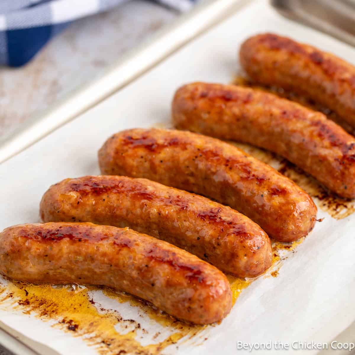 Baked sausage links on a baking pan. 