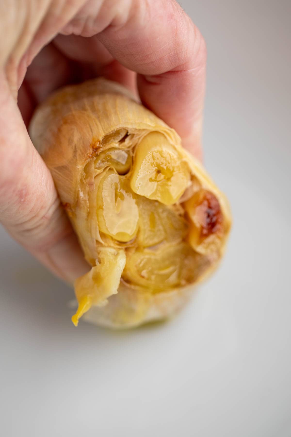 Squeezing garlic cloves out of a head of garlic. 