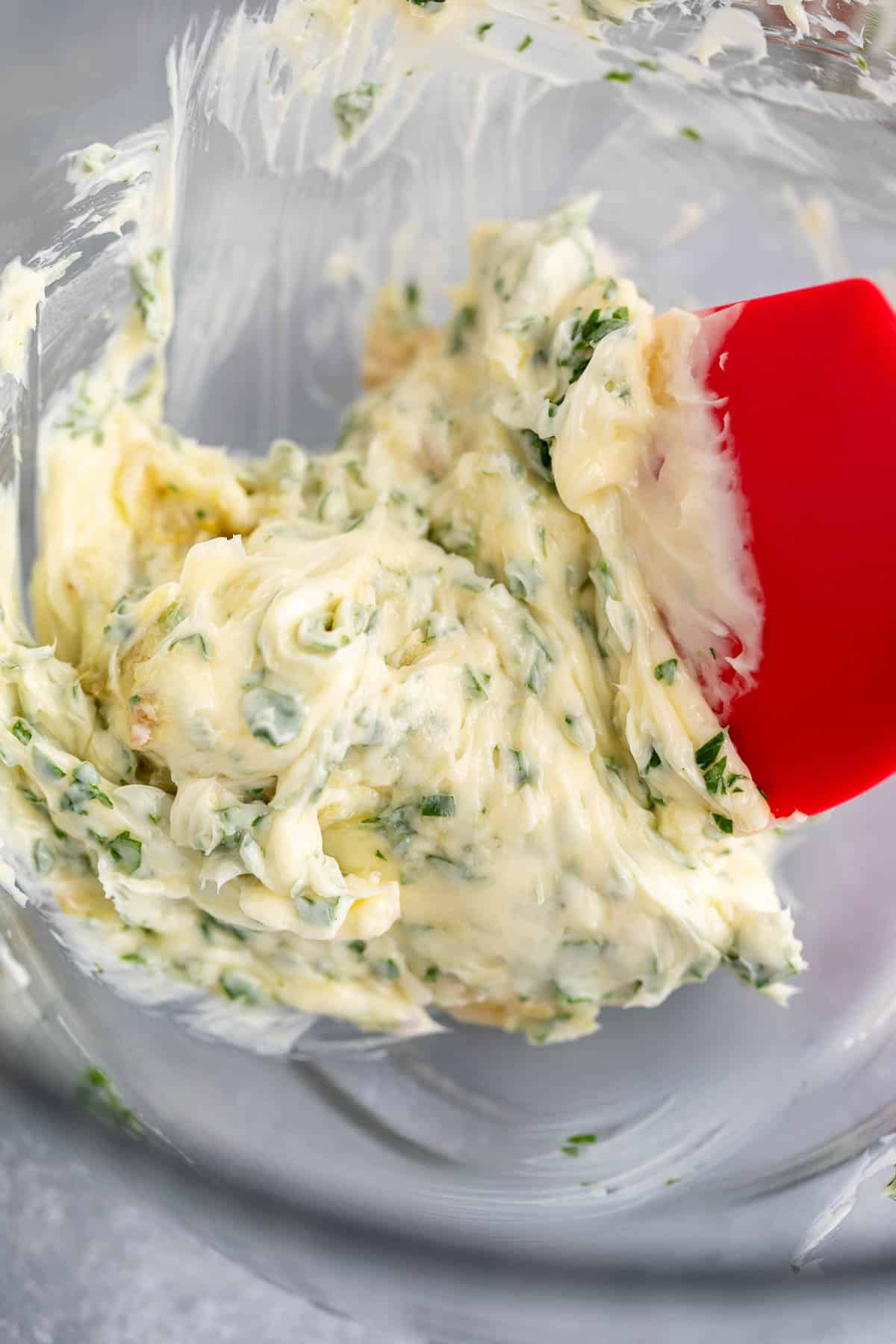 Whipped butter with herbs in a glass bowl.