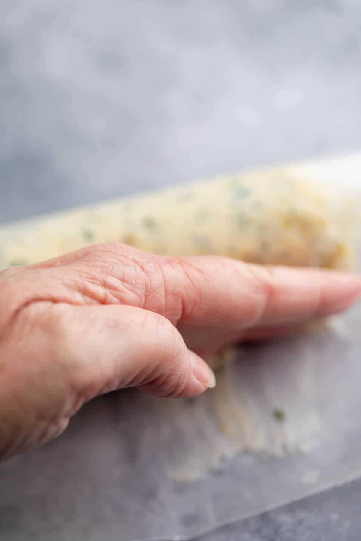 Using the back of your hand to shape a butter roll.