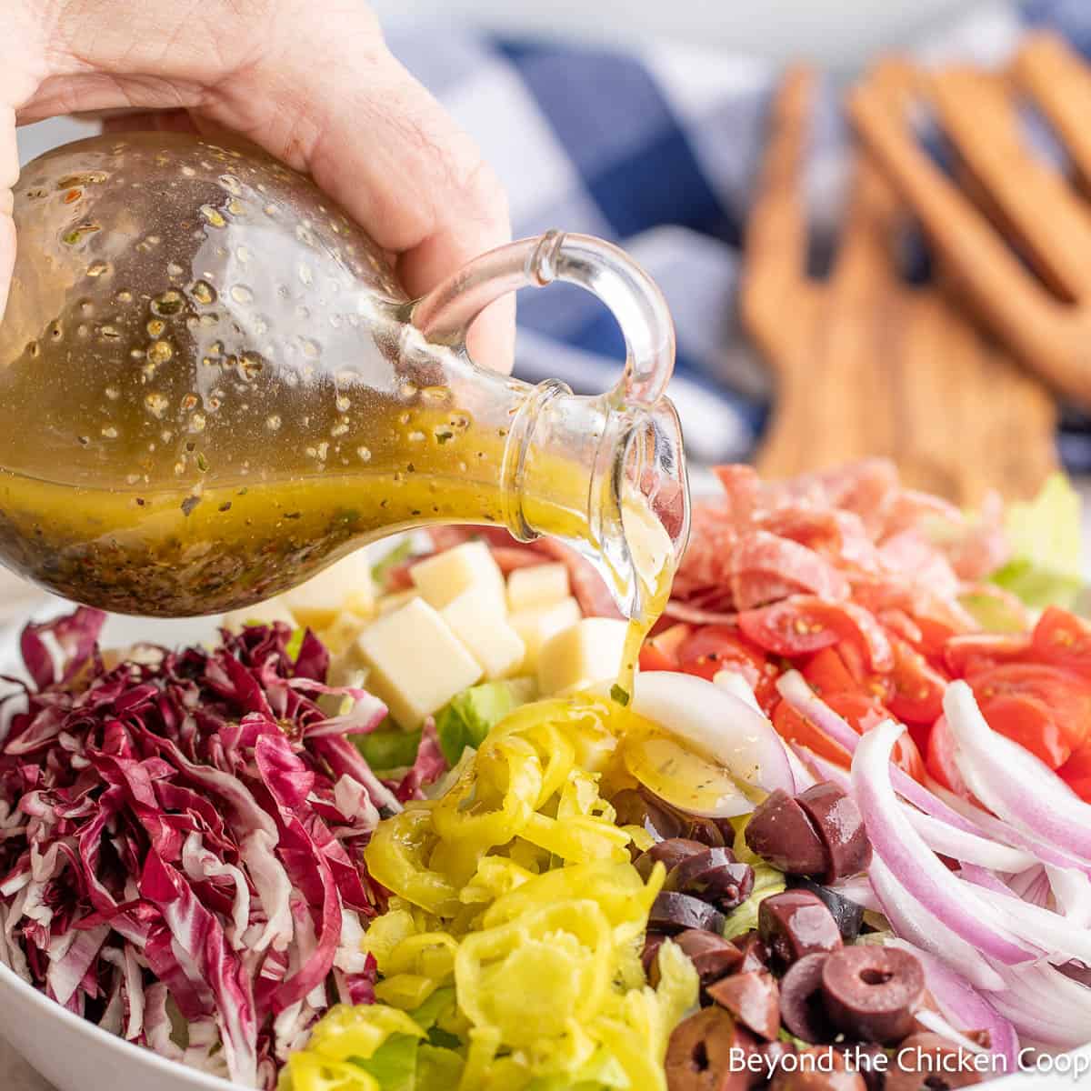 Pouring Italian Dressing over a chopped salad. 