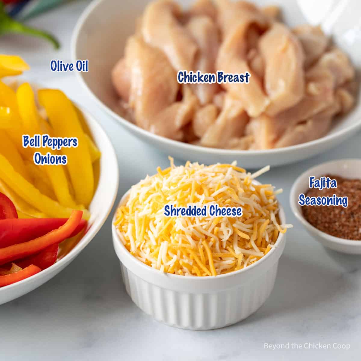 Small bowls filled with sliced chicken, bell peppers and shredded cheese.