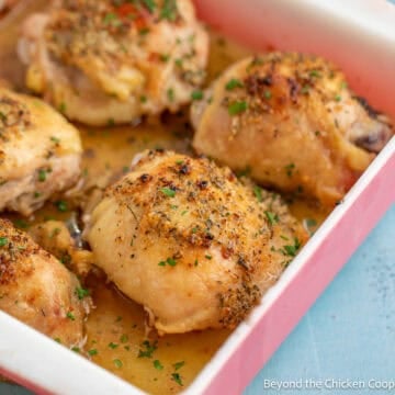 Garlic butter chicken thighs in a casserole dish.