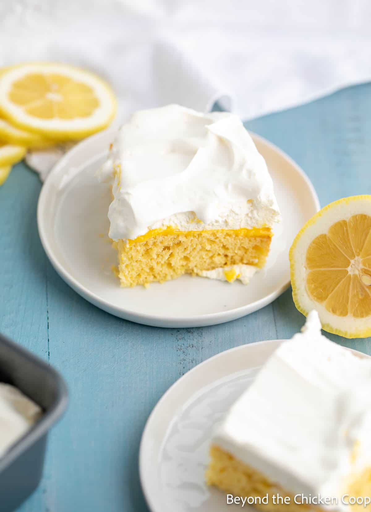 Squares of lemon cake on small white plates. 