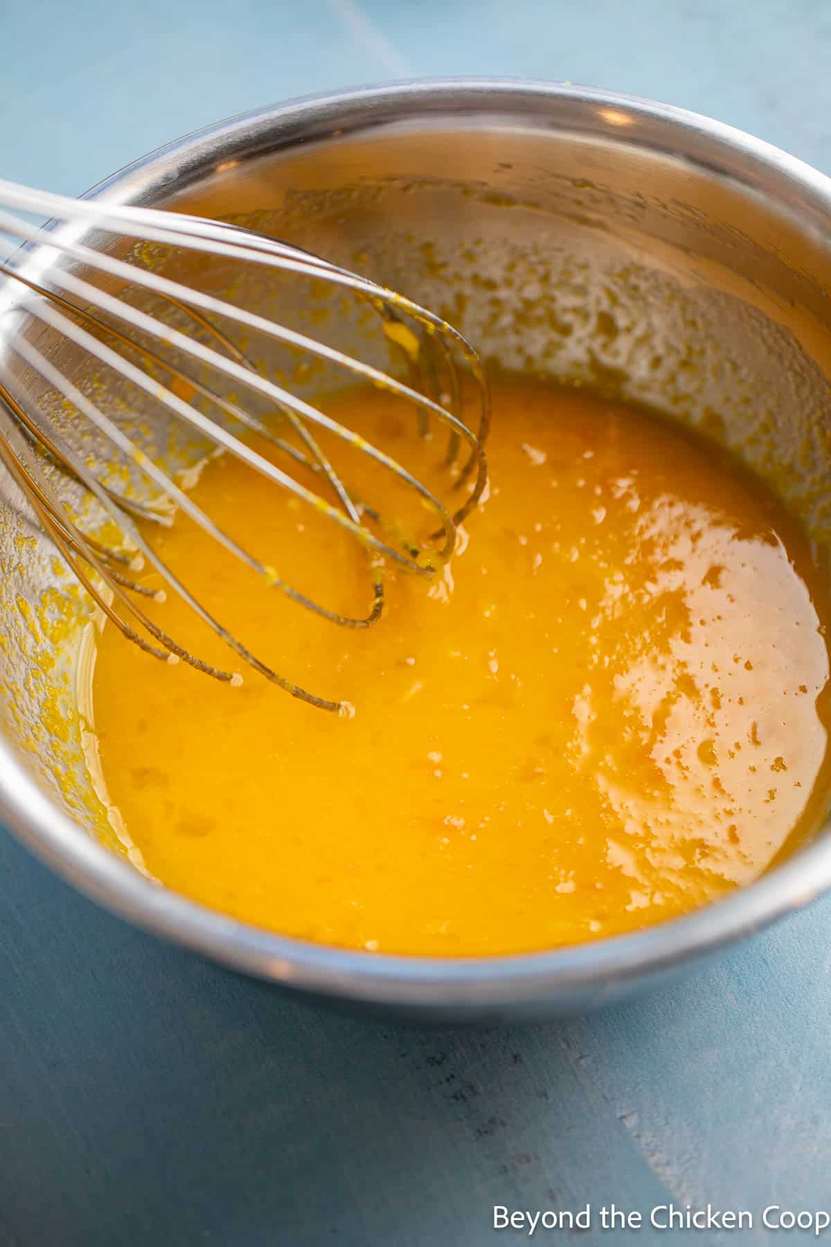 Making lemon curd in a bowl with a whisk. 