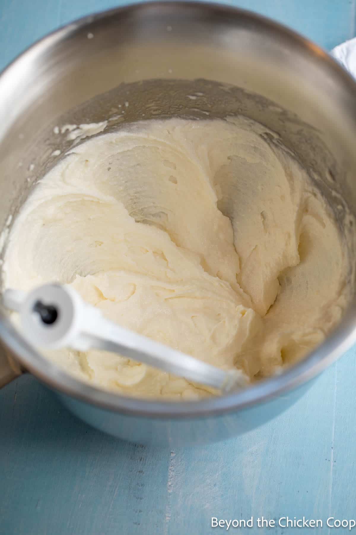 Butter and sugar mixed together in a mixing bowl. 