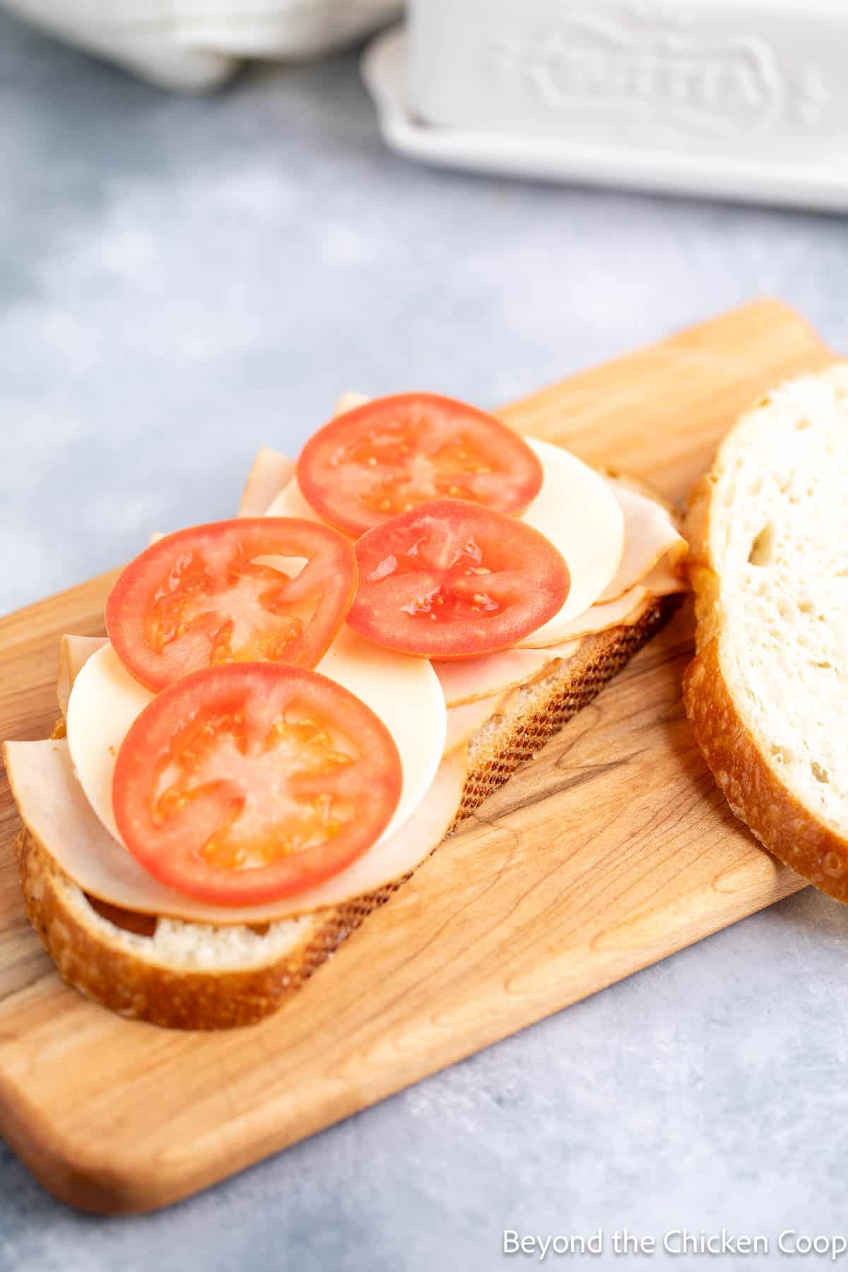 A slice of bread topped with turkey, cheese and sliced tomatoes.