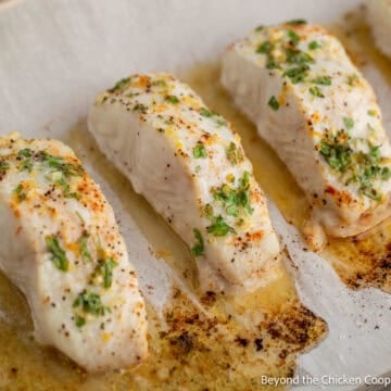 Baked halibut on a baking sheet.