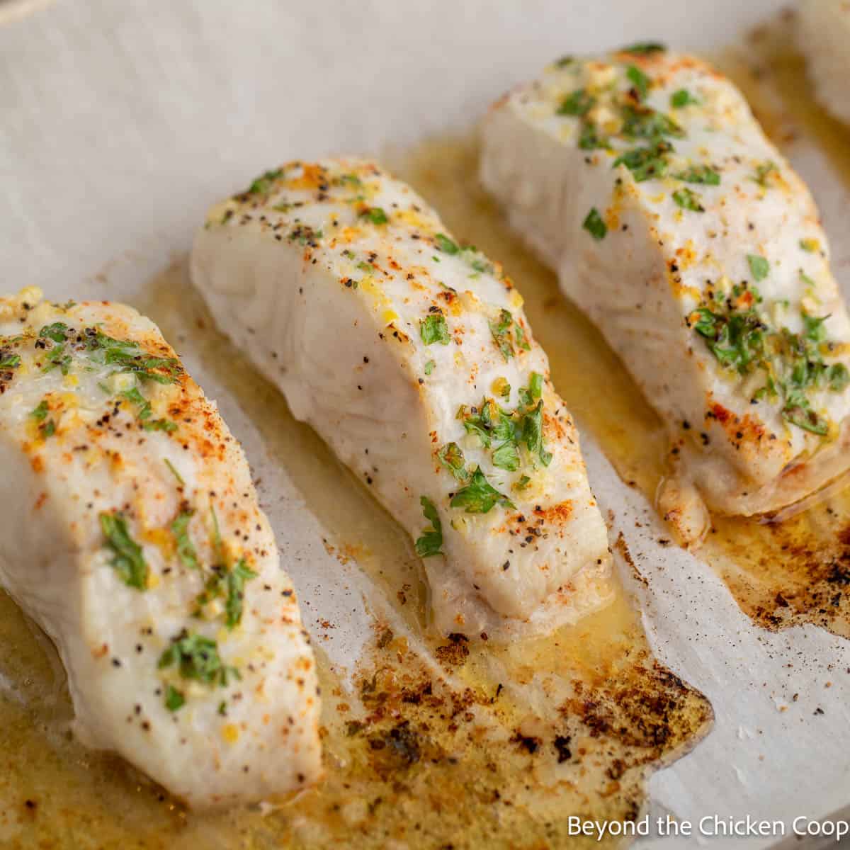 Baked halibut on a baking sheet.