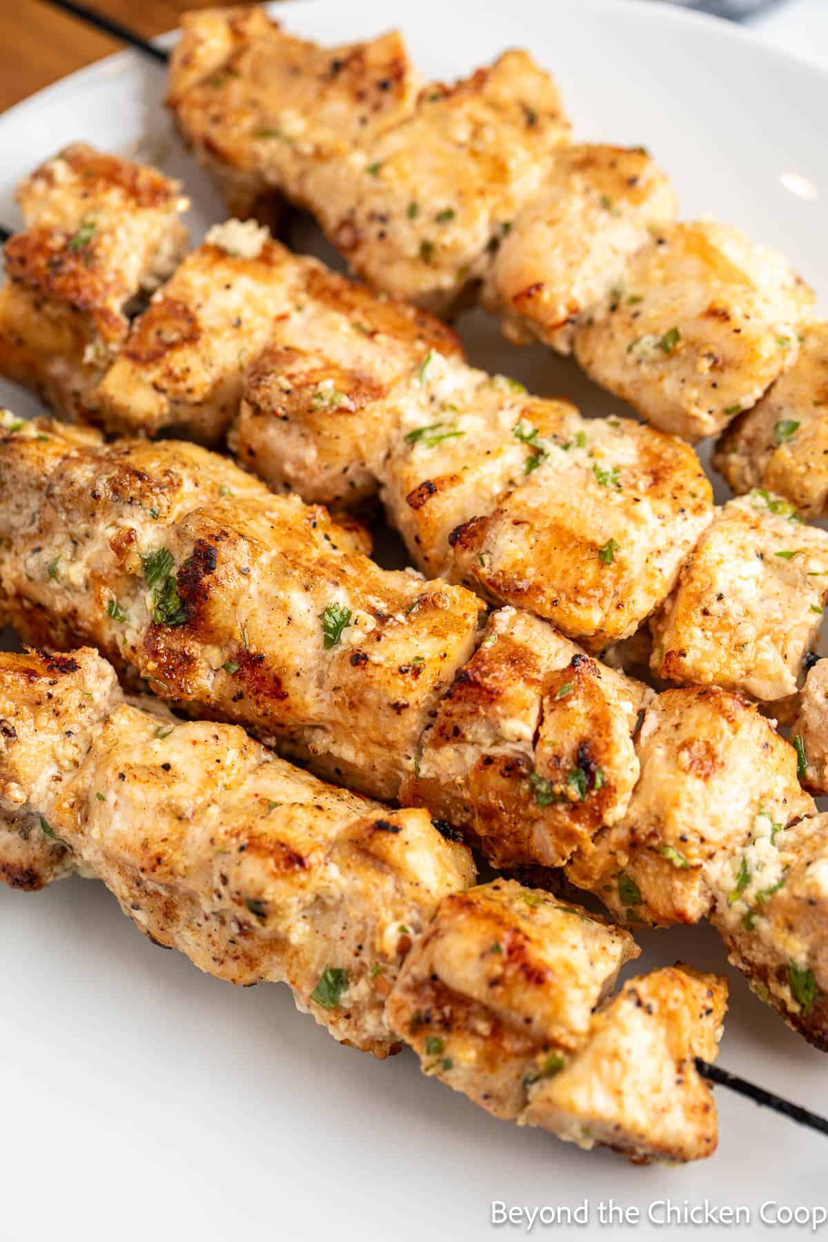 Chicken pieces on metal skewers.