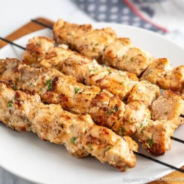 Garlic Parmesan Chicken Skewers on a white dinner plate.