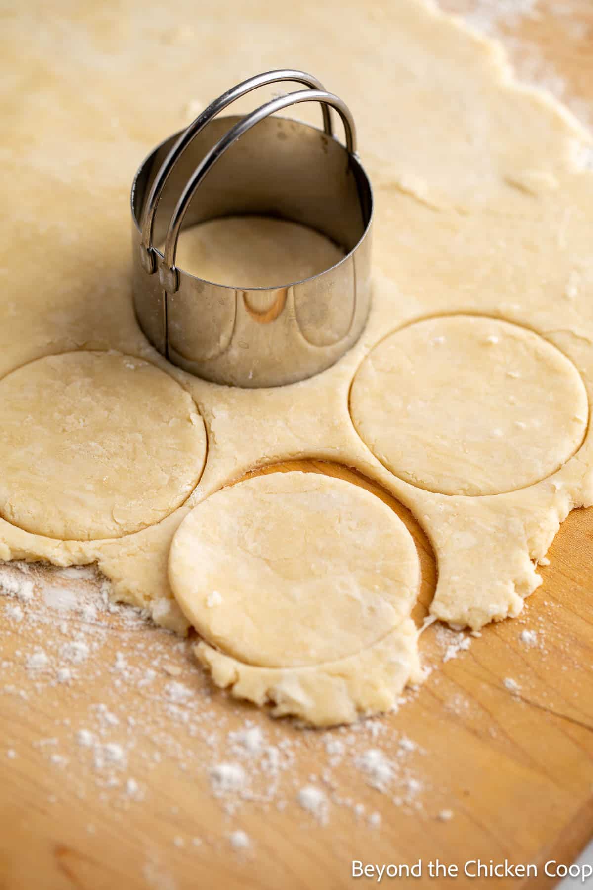 Cutting pie crust into small rounds. 