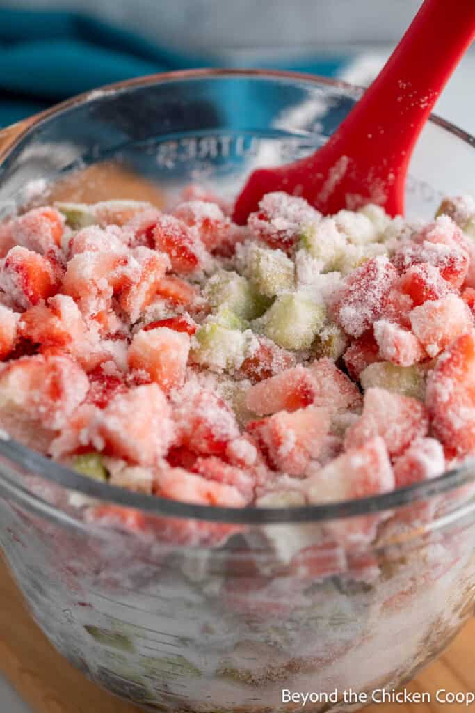 Fruit coated with sugar in a large glass bowl.