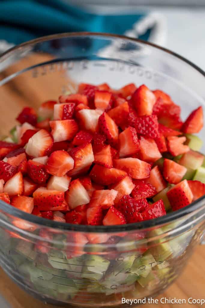 Chopped strawberries and rhubarb in a large glass bowl. 