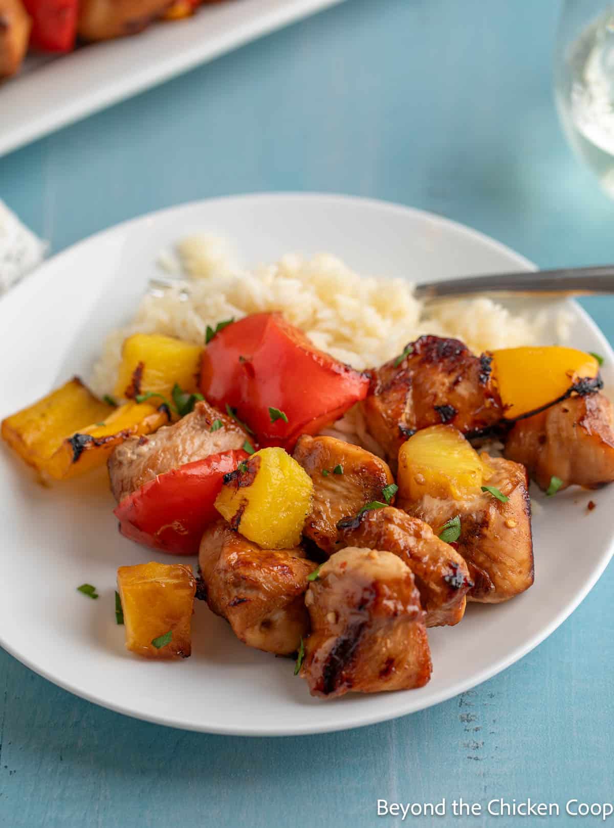 Grilled chicken, peppers and pineapple on a white plate. 