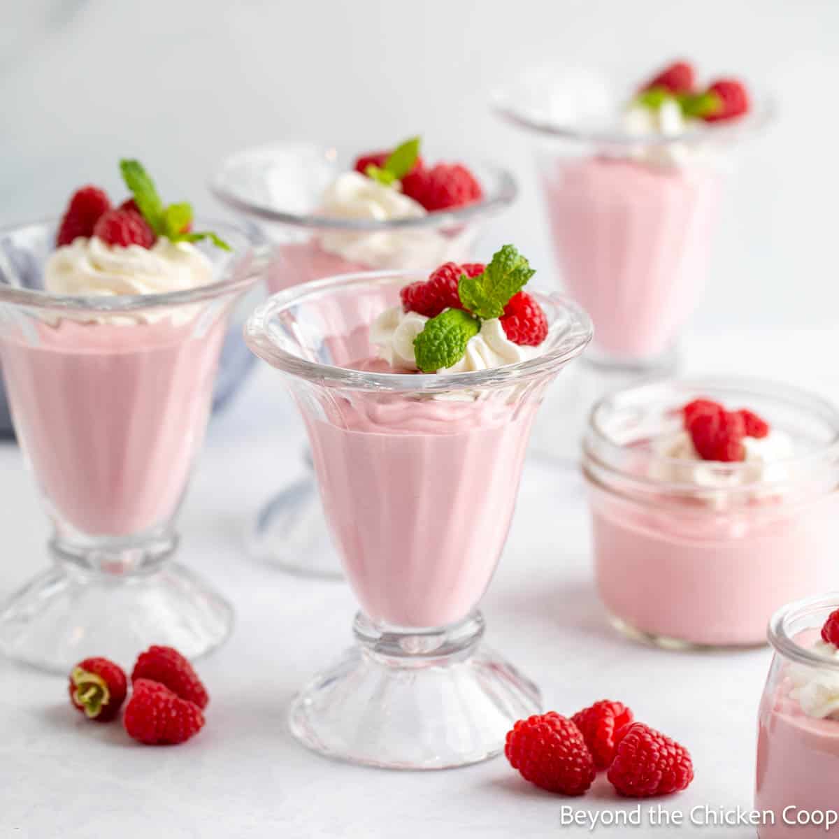 Glasses filled with raspberry mousse and whipped cream. 