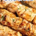 Chicken skewers sprinkled with parsley on a plate.