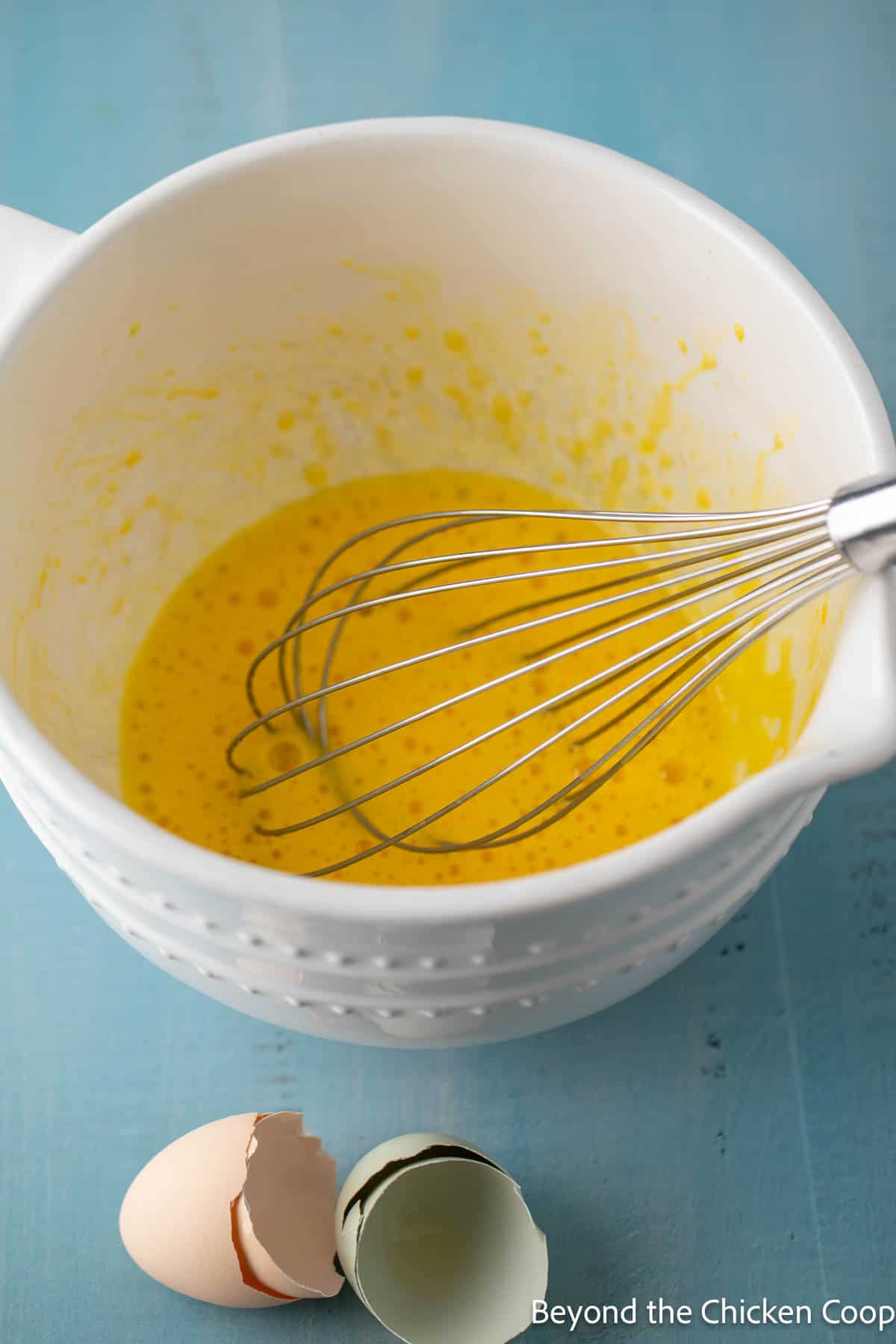 Making waffle batter in a white mixing bowl.