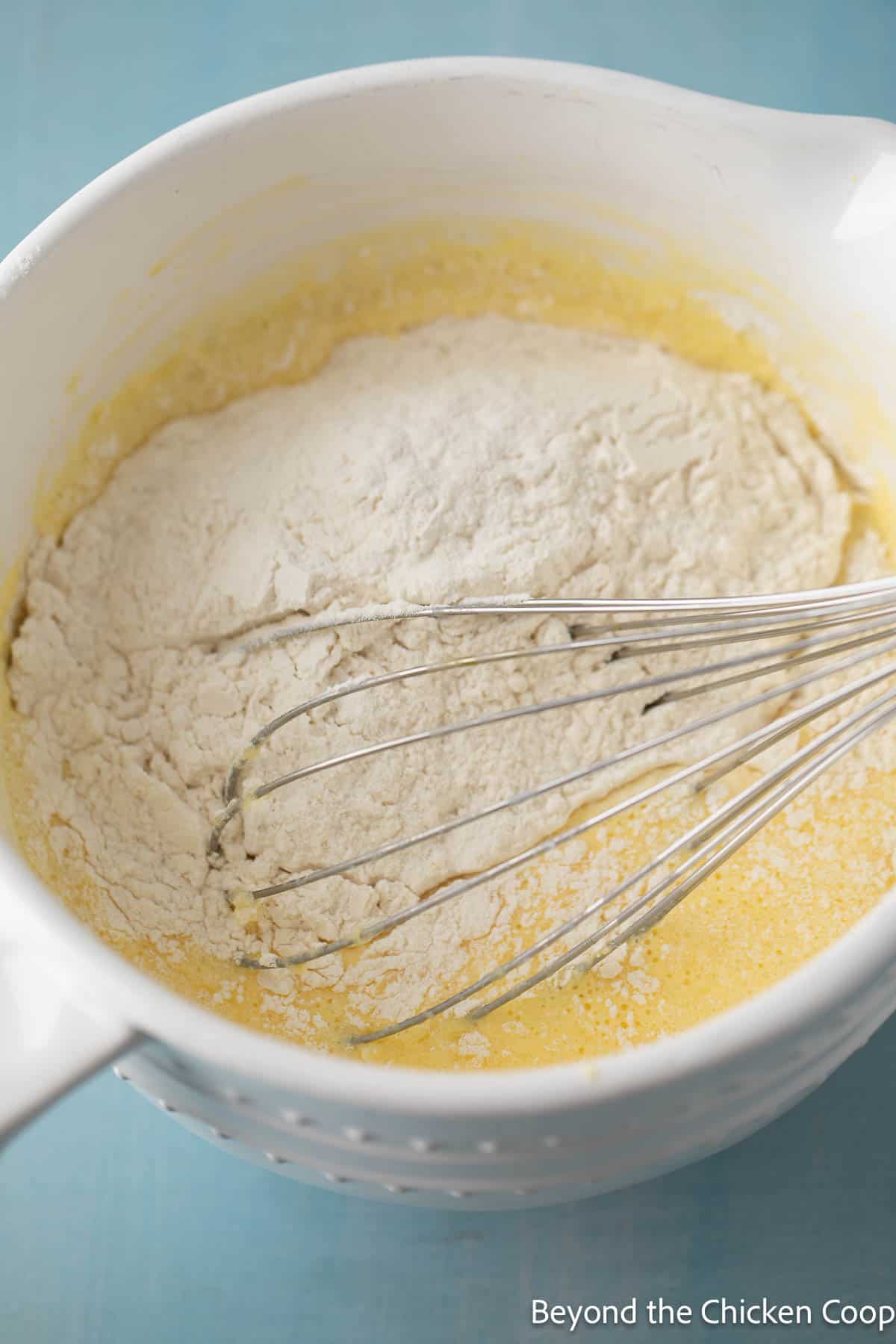 Adding flour to waffle batter.