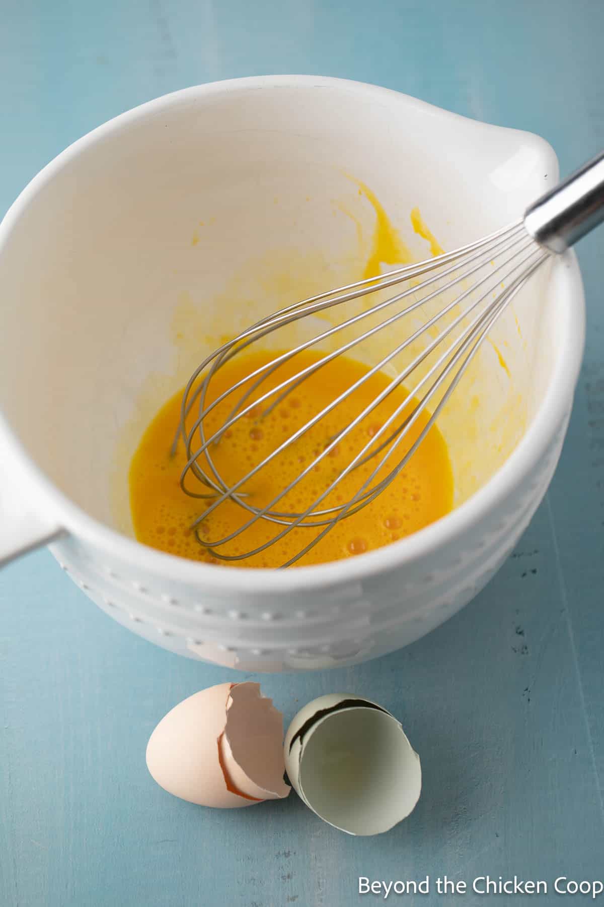 Eggs whisked together in a bowl.
