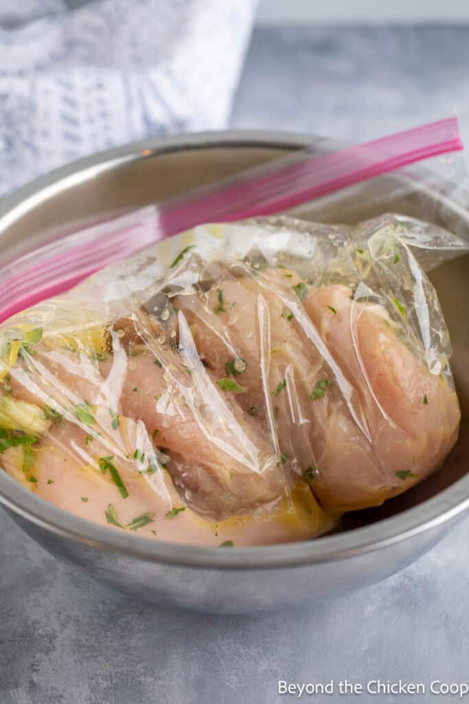Chicken breasts in a bag filled with a lemon marinade.
