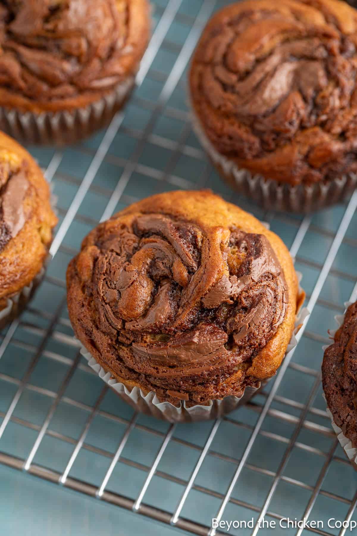 Nutella swirled muffins on a baking rack. 