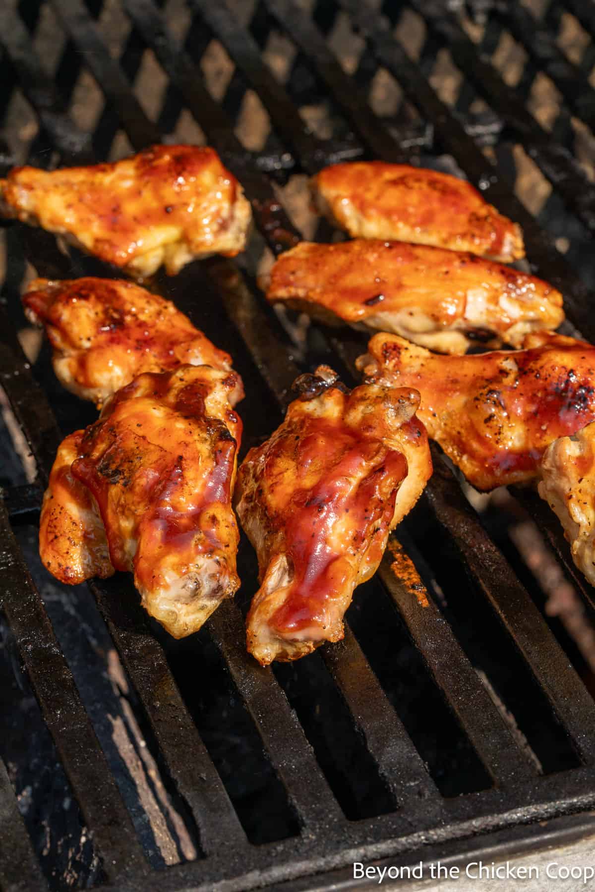 Cooking wings with barbecue sauce on a grill. 