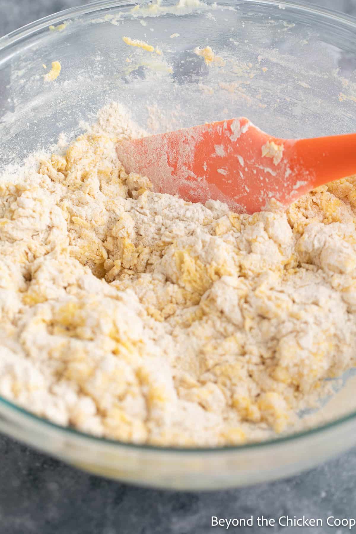 Mixing quick bread batter in a bowl with a spatula. 
