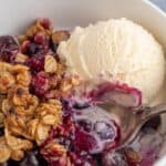 Blueberry dessert topped with vanilla ice cream.