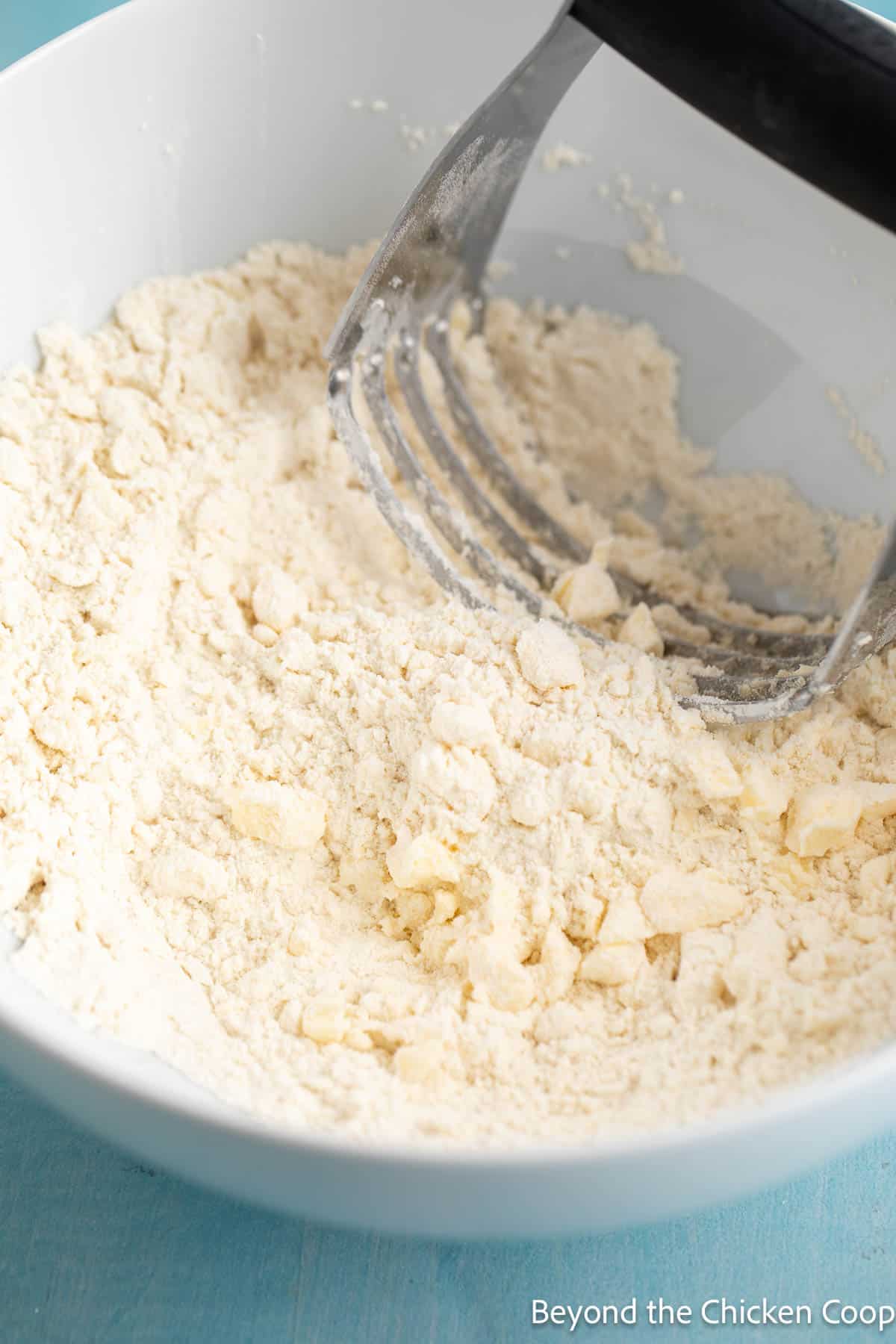 Blending the butter into flour with a pastry blender. 