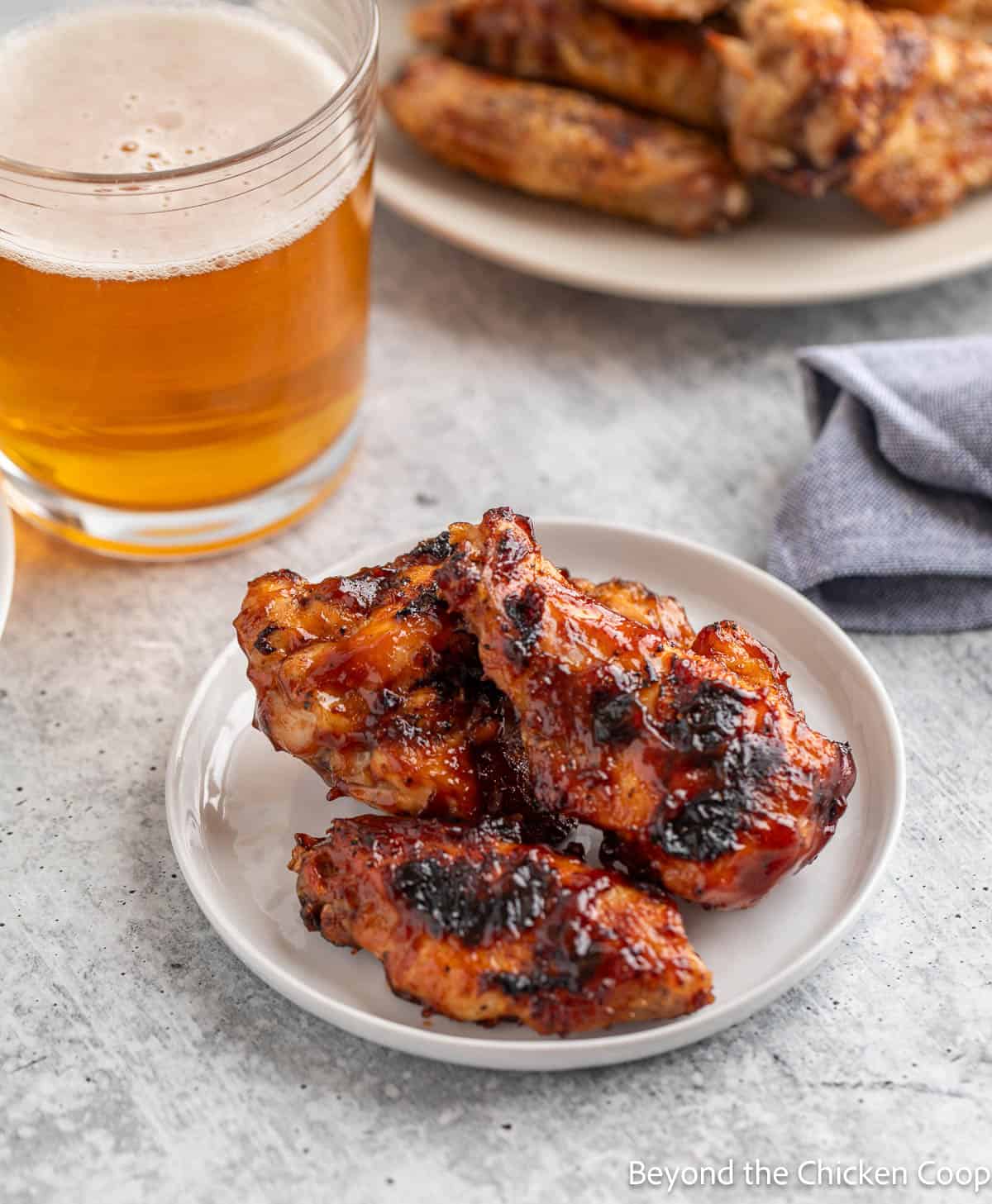 Wings covered with barbecue sauce on a small plate. 